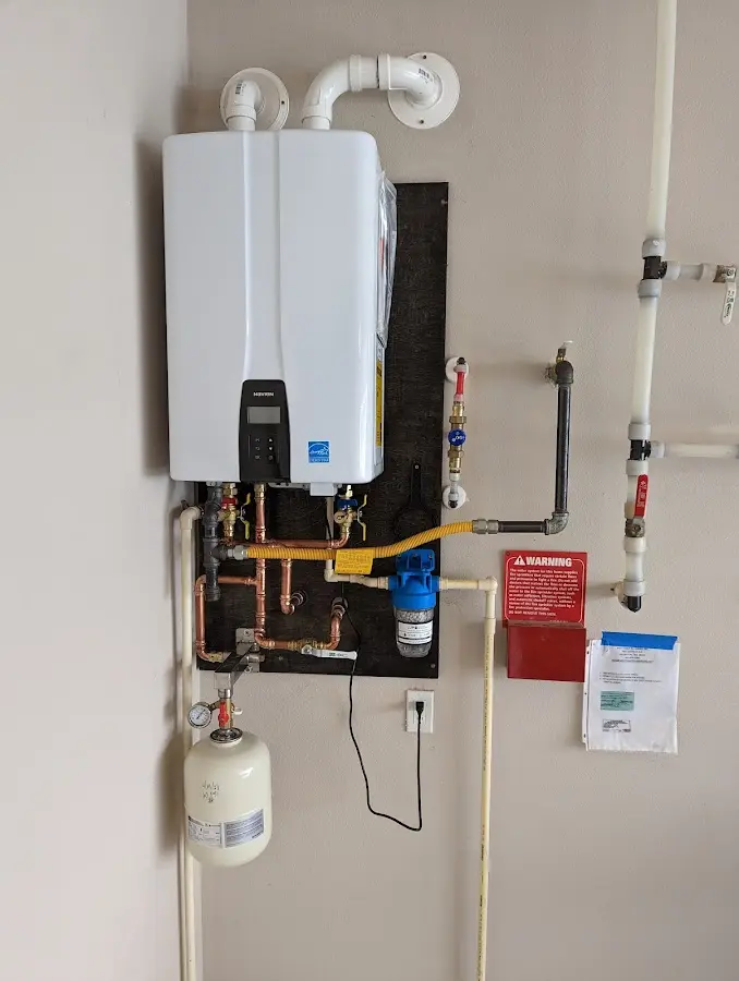 Professional plumber installing copper piping in a Lenox home